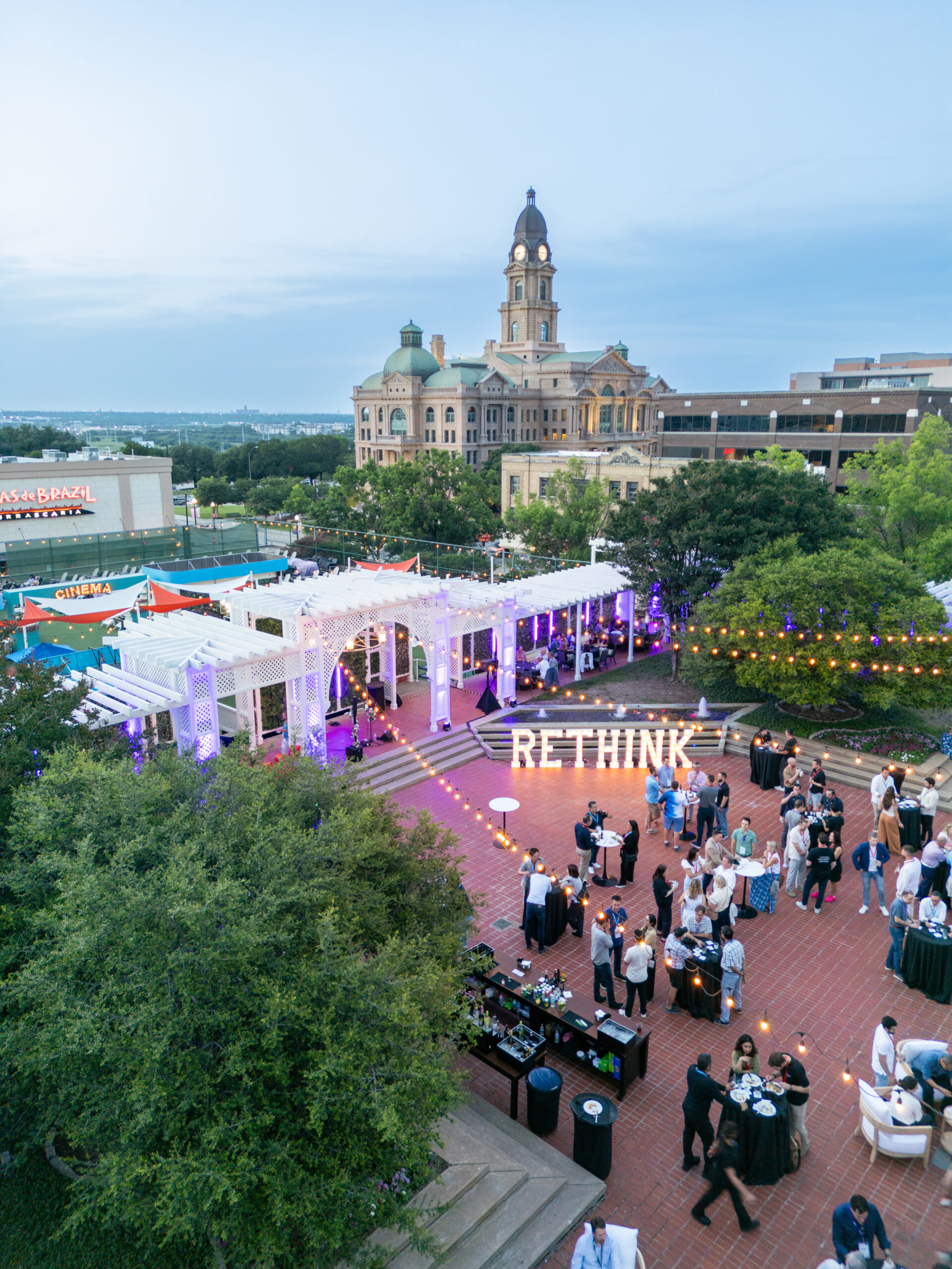 drone photo over fort worth texas showing rooftop party at the worthington hotel with courthouse in the background for corporate conference event by lightly photography