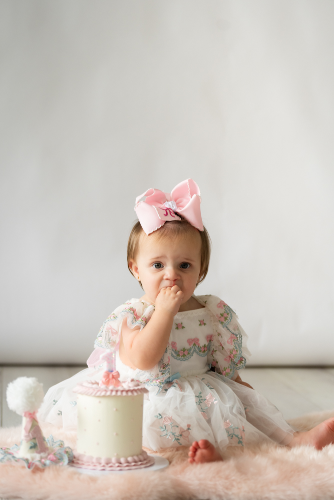 Kollyns hesitating over her first birthday smash cake in the studio